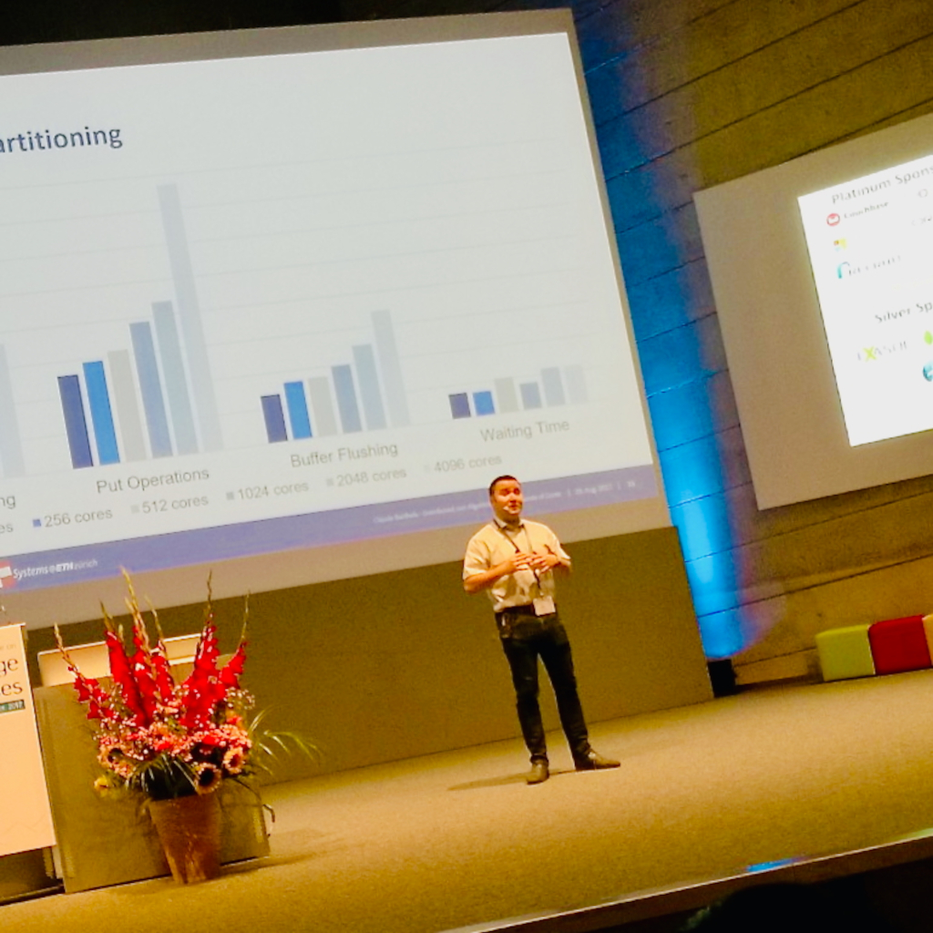 Claude presenting on a large stage